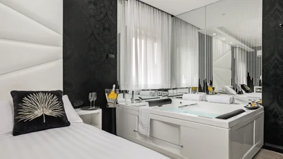 Camera moderna con vasca idromassaggio e letto singolo con cuscino decorativo