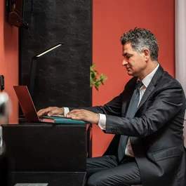 Uomo in abito che lavora al laptop in ufficio moderno