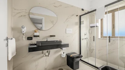 Bagno moderno con lavabo nero e doccia in vetro