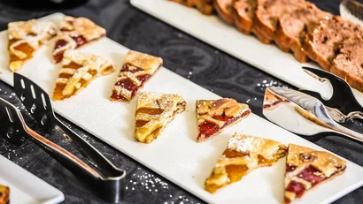 Fette di torta con marmellata su piatto bianco con posate accanto