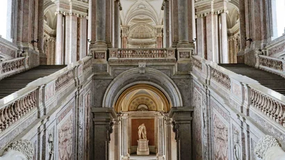 Interno di un palazzo storico con scale imponenti e statue di leoni