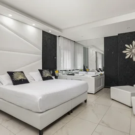 Camera da letto moderna con letto bianco e vasca idromassaggio