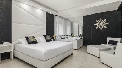 Camera da letto moderna con letto bianco e vasca idromassaggio