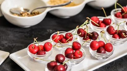 Ciliegie rosse in bicchieri di vetro su un vassoio bianco