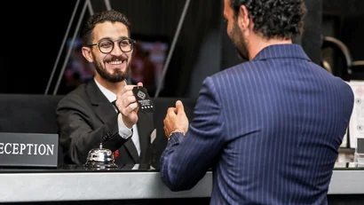 Receptionist sorridente consegna chiave della camera d'hotel a un cliente