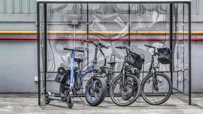 Biciclette e monopattino elettrico parcheggiati sotto una pensilina